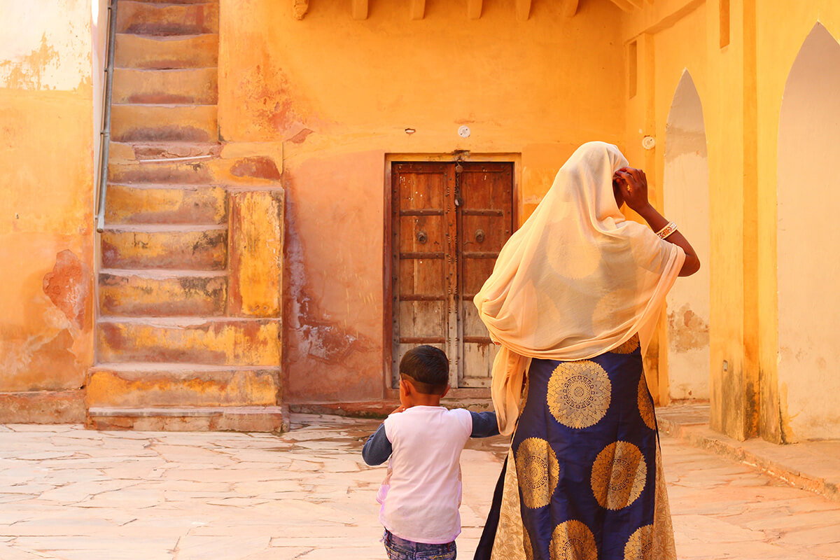 Mother and child walking in colourful building in India