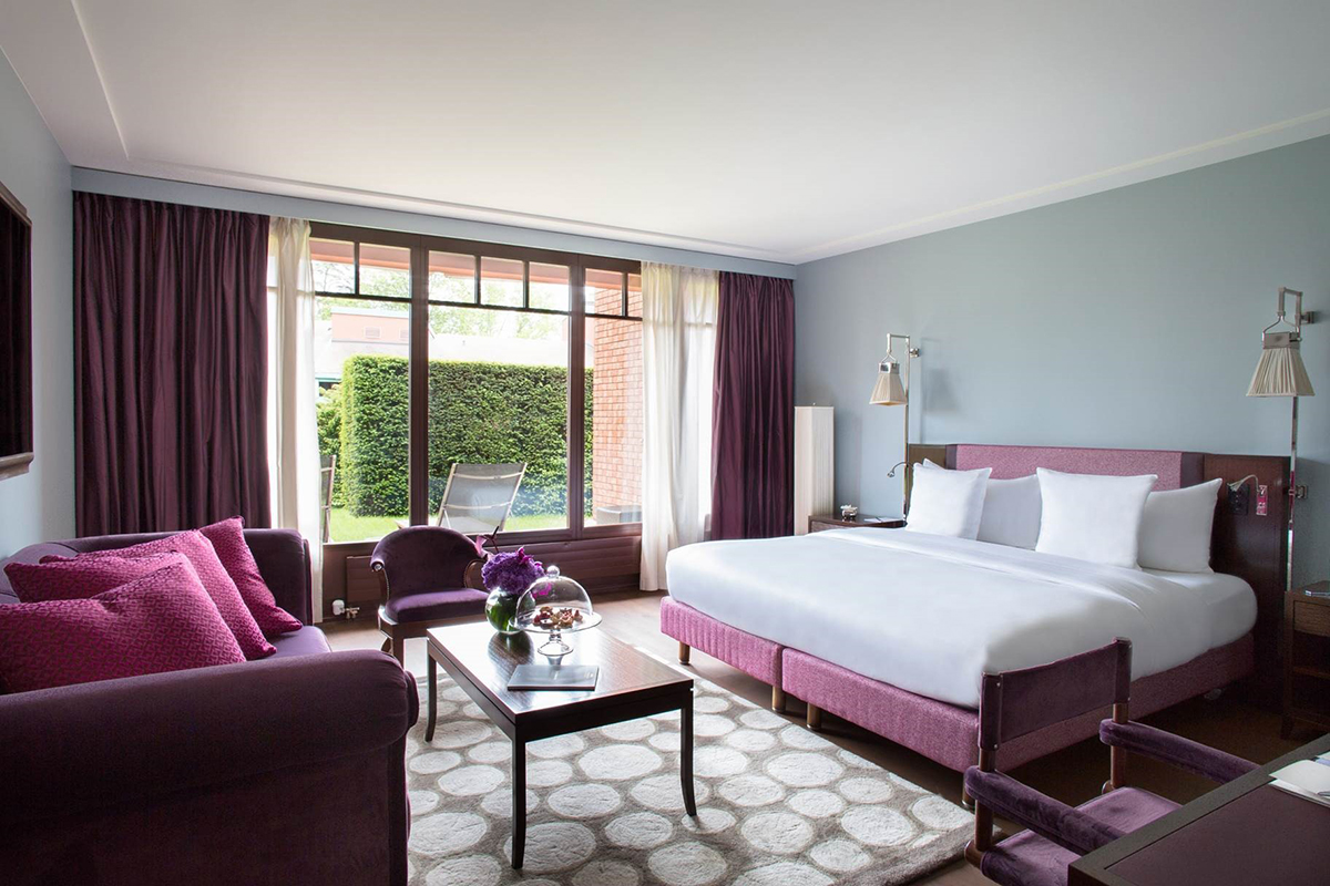 Luxury hotel room decorated in white and magenta