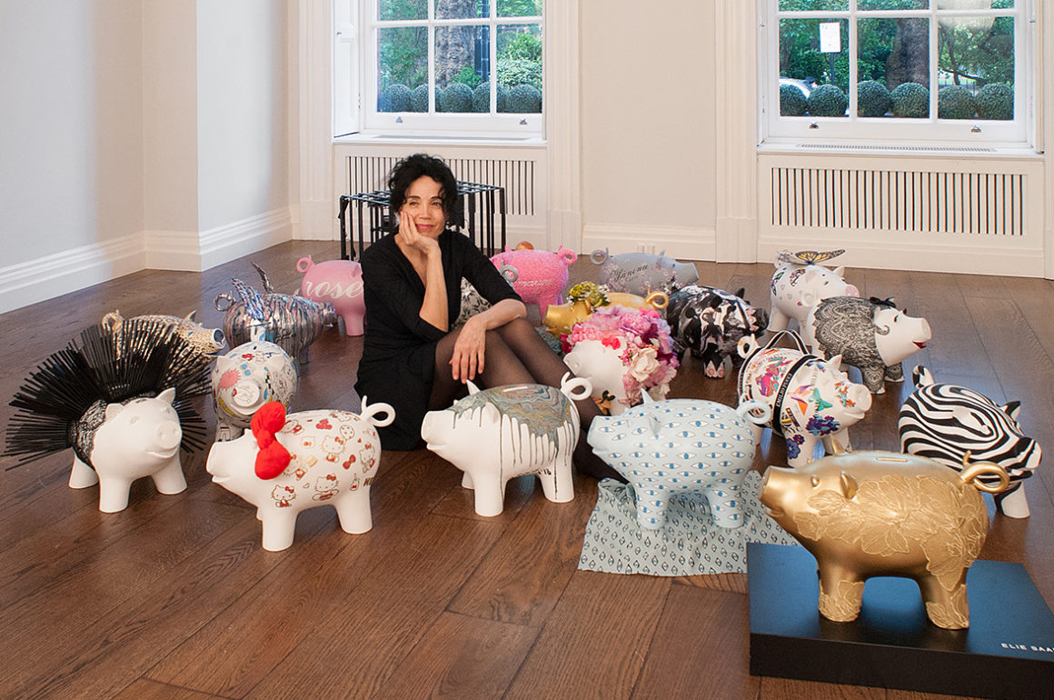 Artist Mouna Rebeiz sits amongst bespoke piggy banks