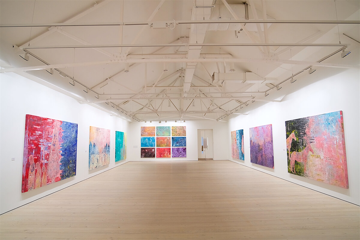 white open plan gallery space with large colourful canvases on the walls