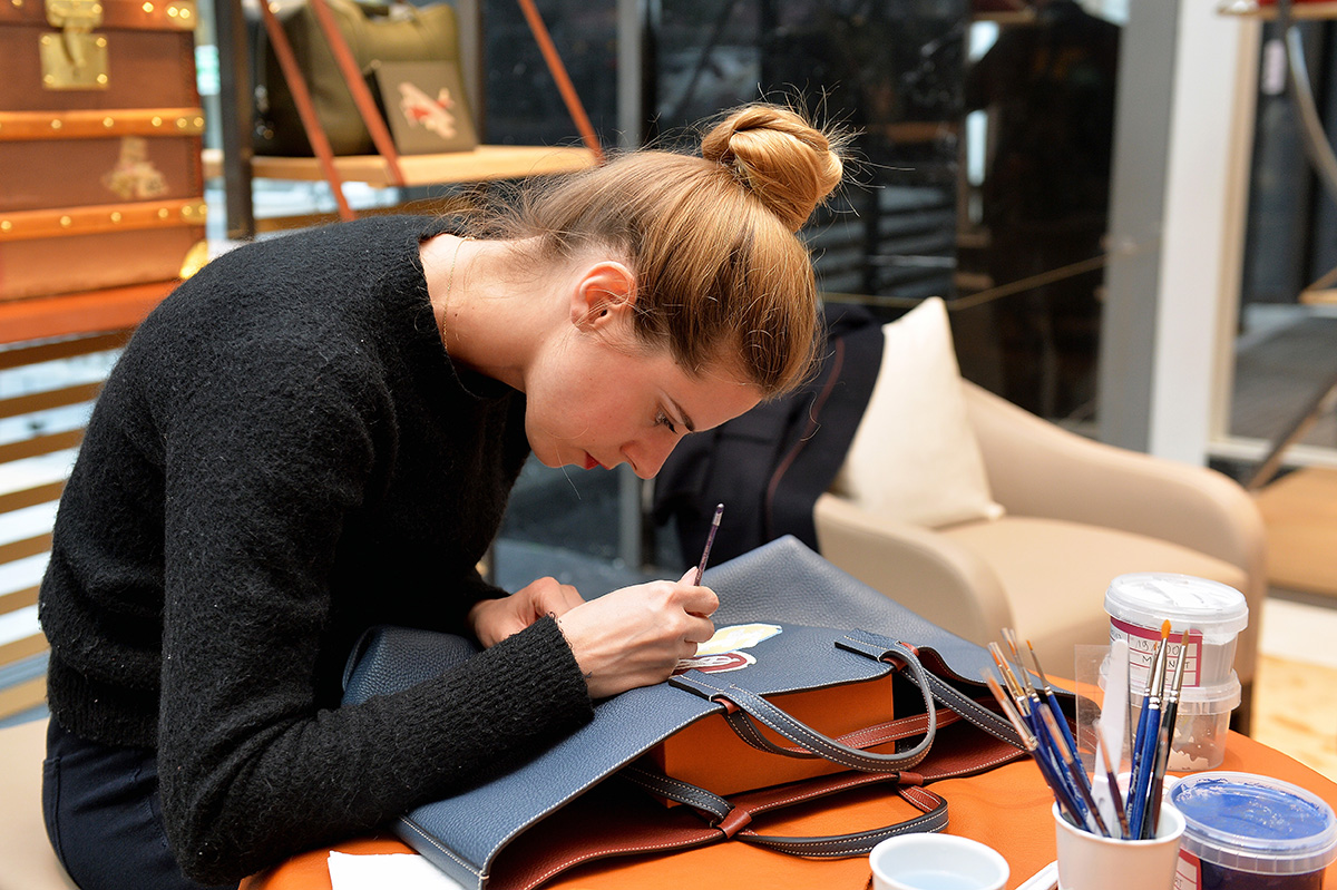 Artist painting onto leather bag