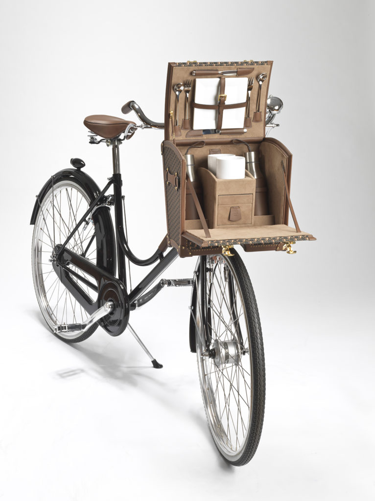 old fashioned luxury picnic trunk fitted to the handlebars of a bicycle