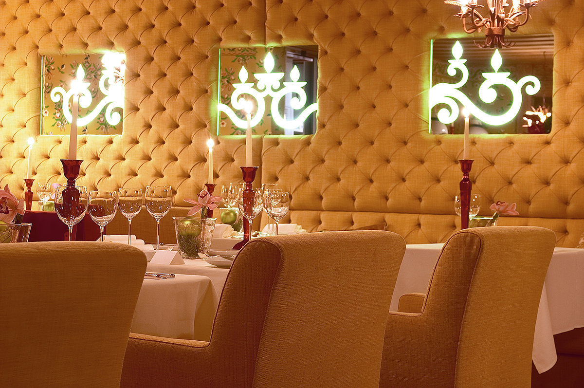 super luxury interiors of a restaurant with plush gold fabric walls and candles