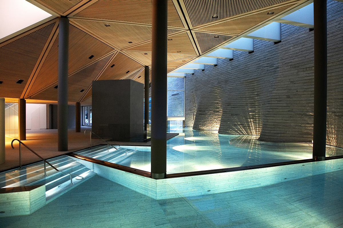indoor luxury swimming pool with stone walls and under water lighting