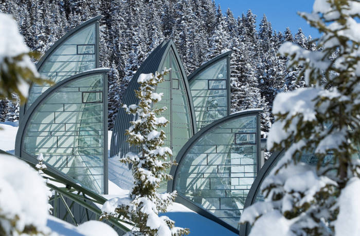 striking architecture of a hotel in the snow set against a forest