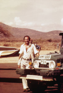 Young Geoffrey Kent standing by the front of a truck