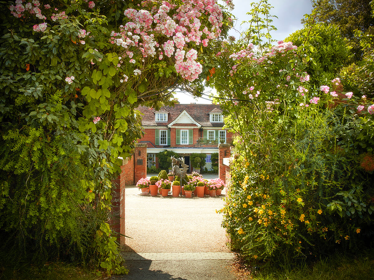 Entrance way to Chewton Glen with pink roses surrounding gates