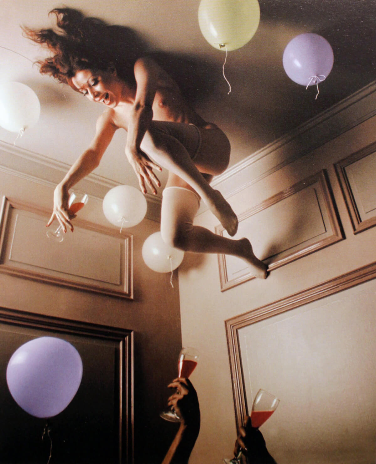 image of woman lying topless on the floor surrounded by balloons