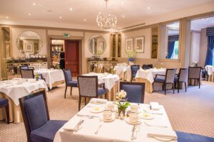 Luxury modern interiors of hotel restaurant with white tablecloths and purple seats