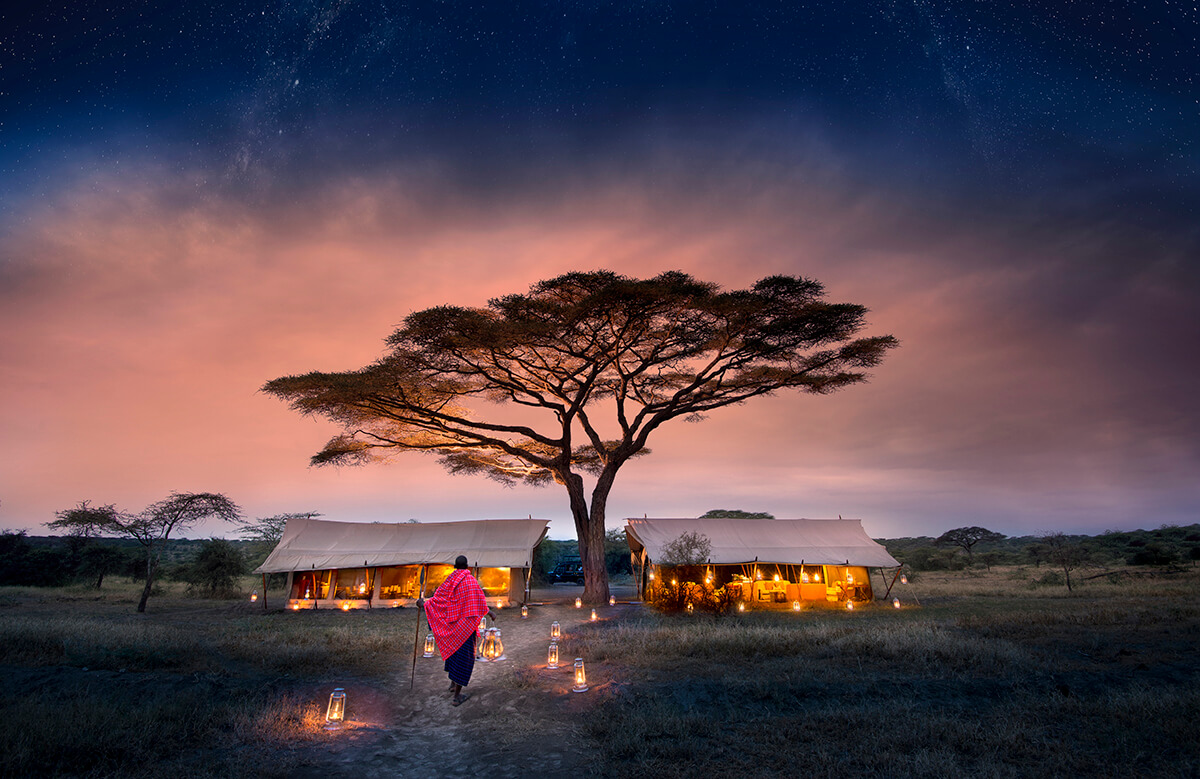 luxury safari tents lit by candles at nighttime