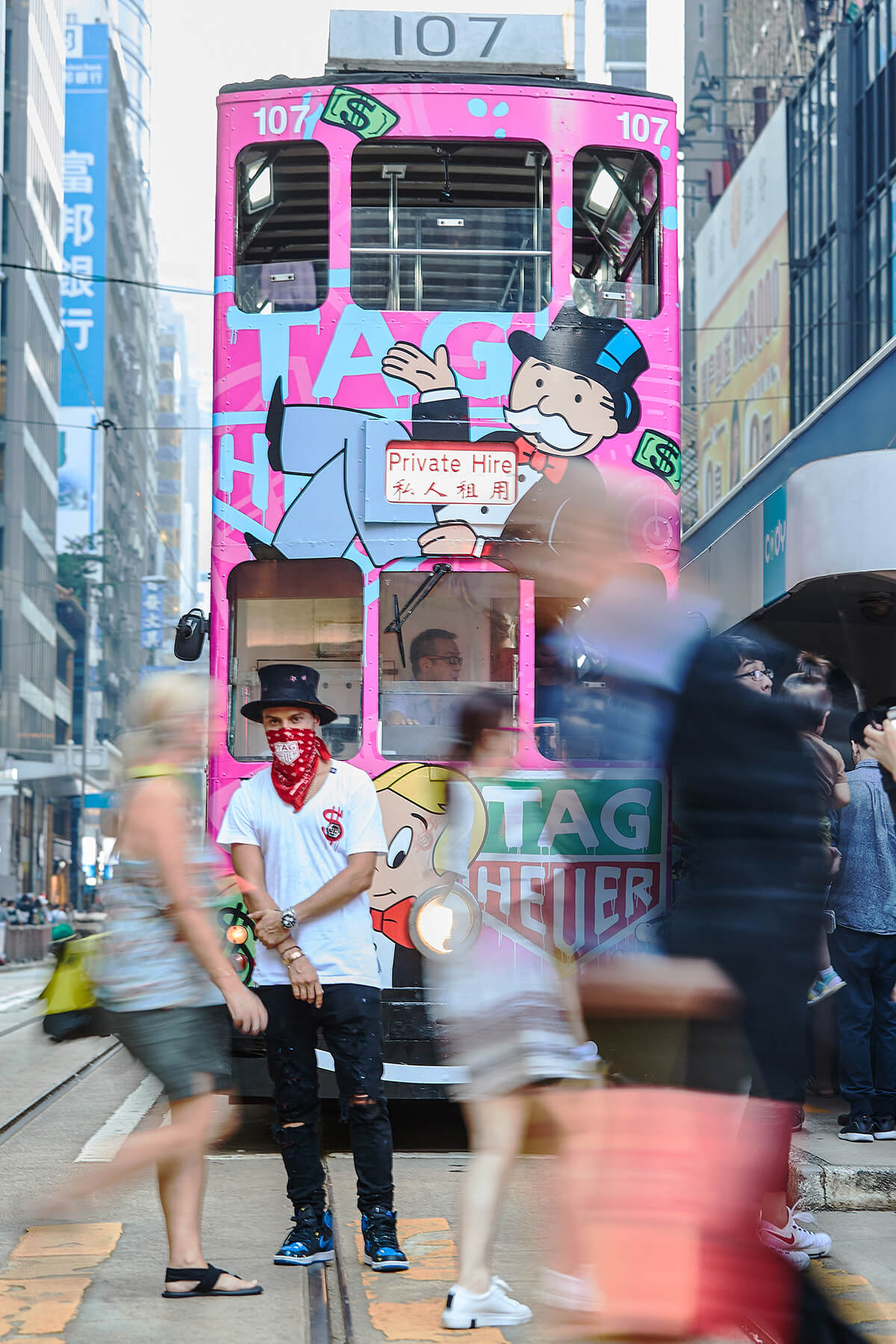 Street artist Alec Monopoly wearing hat and scarf covering half of his face