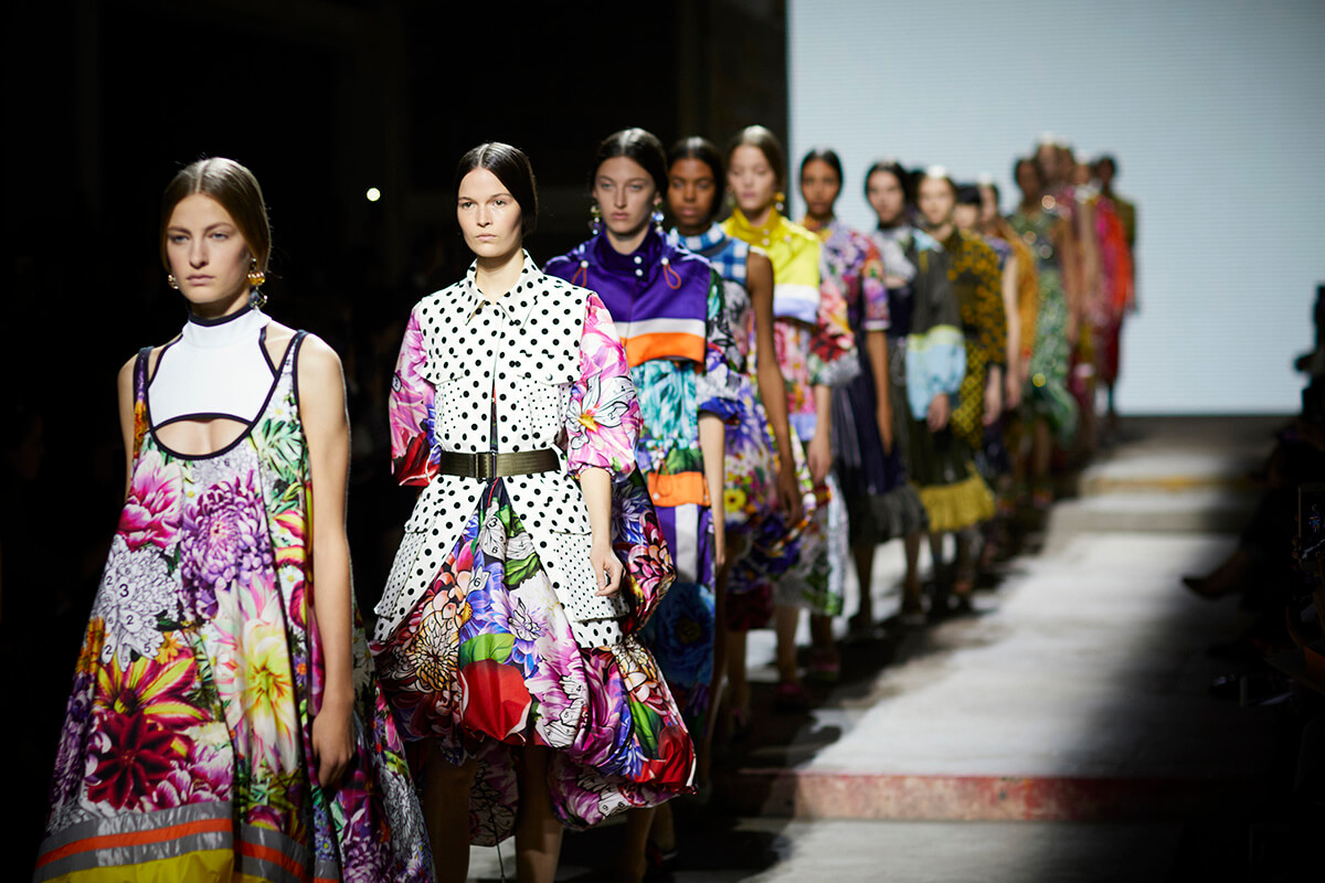 Models dressed in colourful costume walking down the catwalk