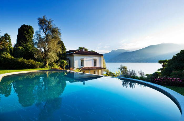 Infinity pool with a lake and mountains in the distance