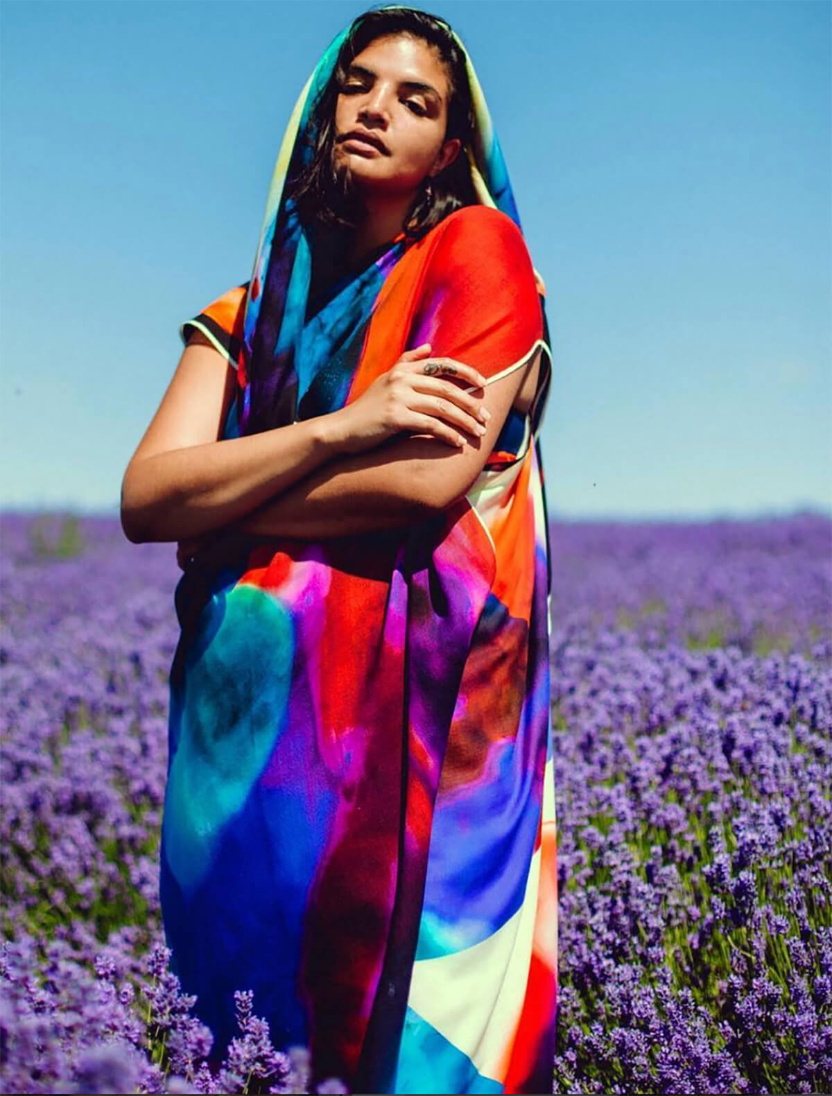 Model standing in lavender field wrapped in colourful shawl