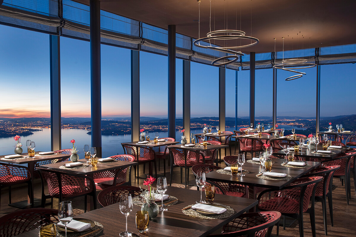 Luxury restaurant dining room with large glass windows providing views of a lake