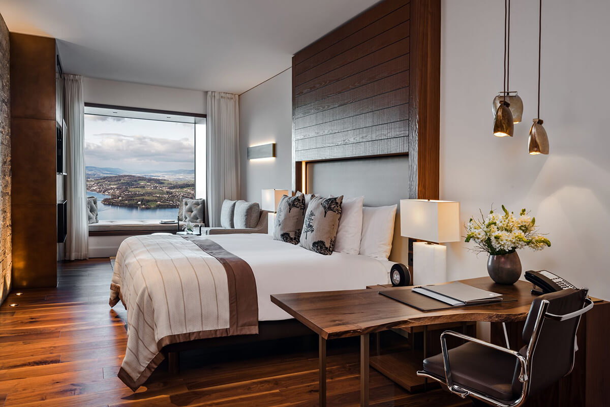 Luxury hotel bedroom with views of a lake through the window