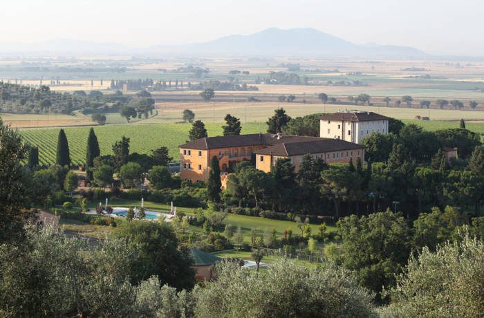 Luxury mansion building with manicured gardens and an outdoor swimming pool