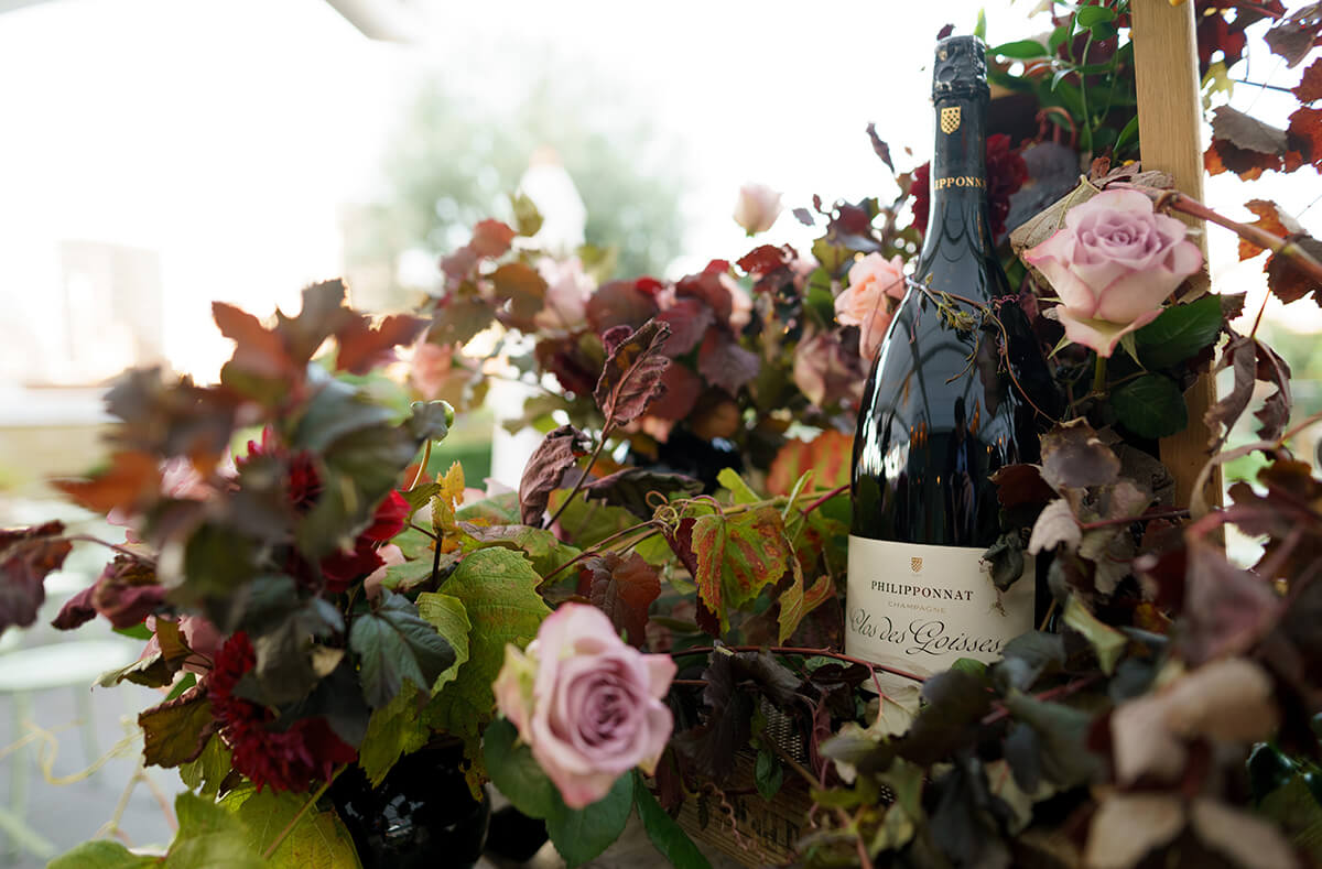 A bottle of Philipponnat champagne surrounded by roses