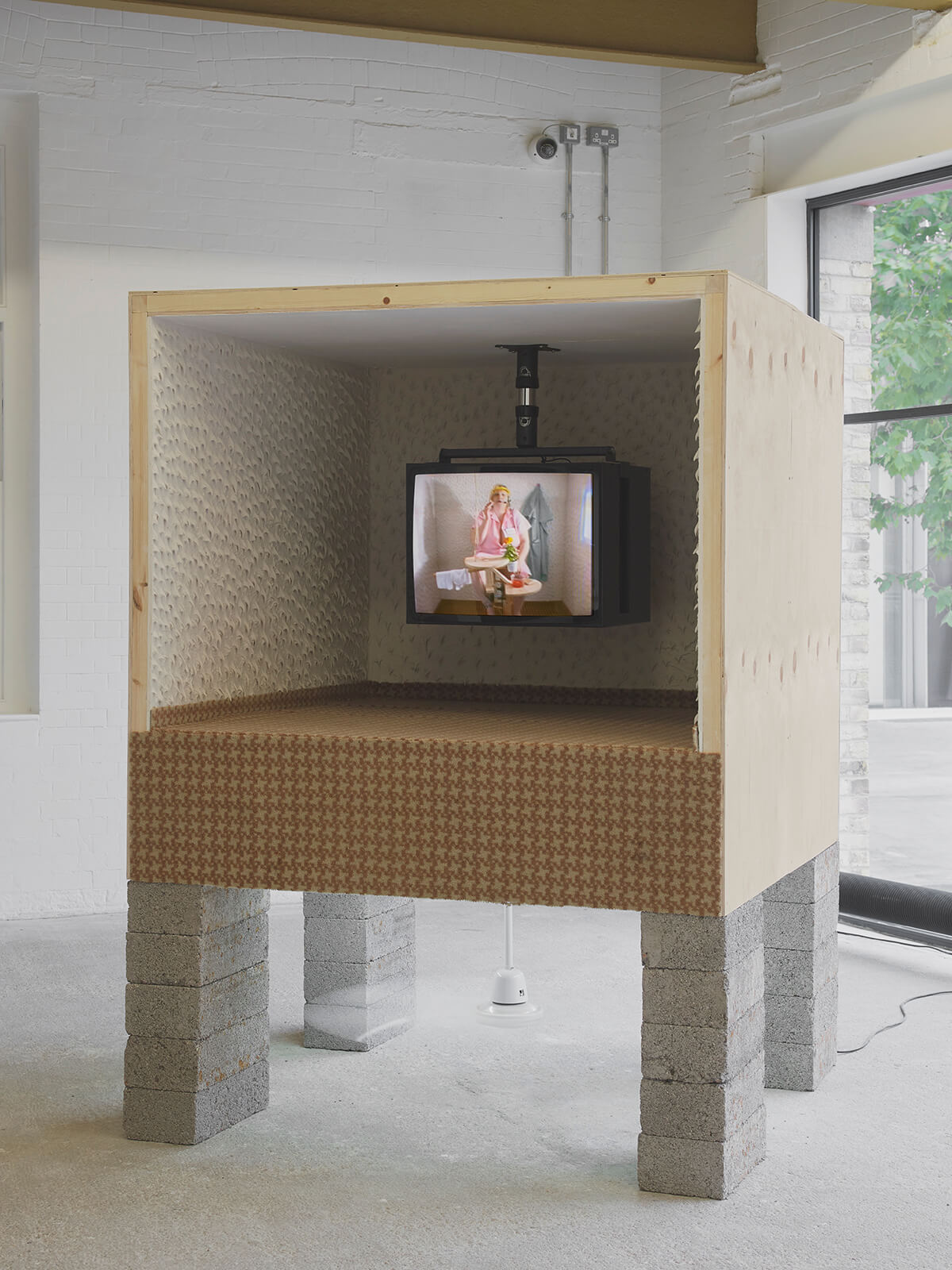 Image of a television inside a box on concrete legs