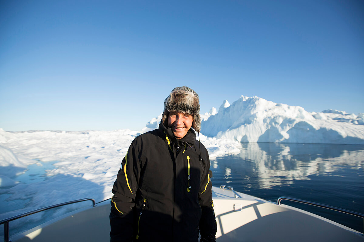 Travel expert Geoffrey Kent pictured on a cruise ship in the arctic ocean surrounded by glaciers
