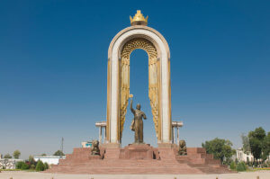 An arched golden monument with a statue of a man in the centre