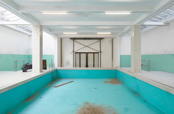 Image of an old empty swimming pool with a turquoise surface