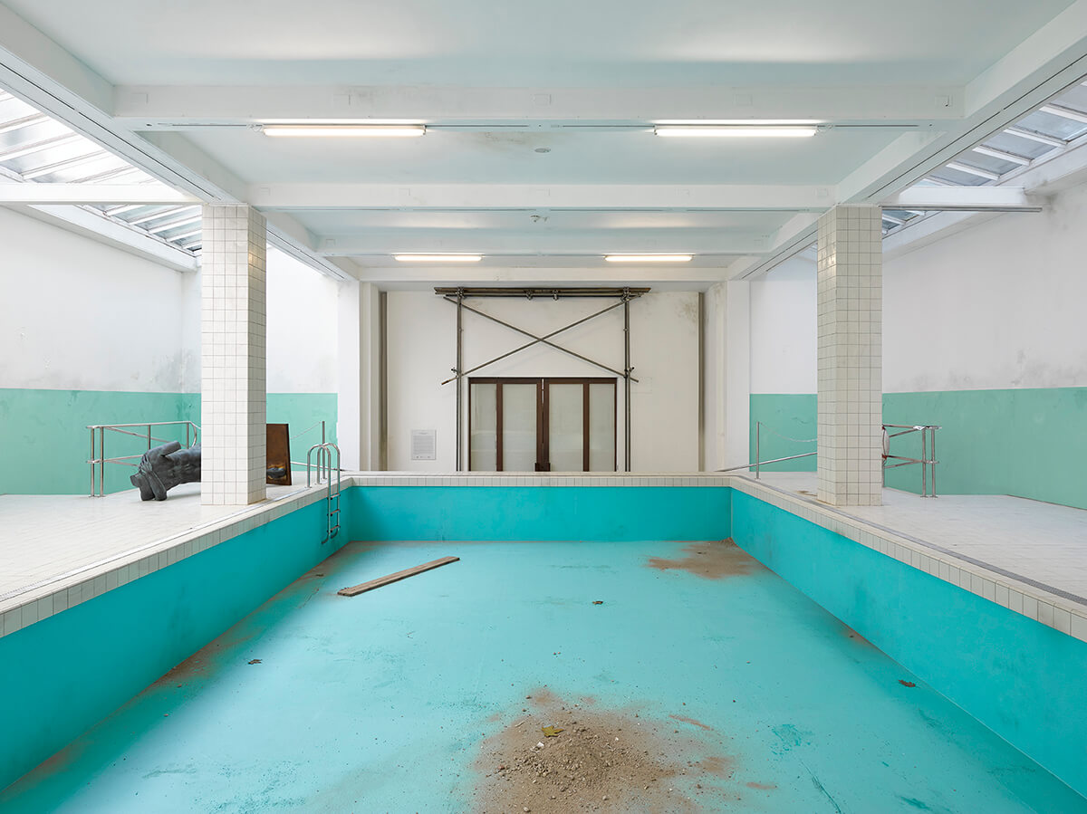 Image of an old empty swimming pool with a turquoise surface