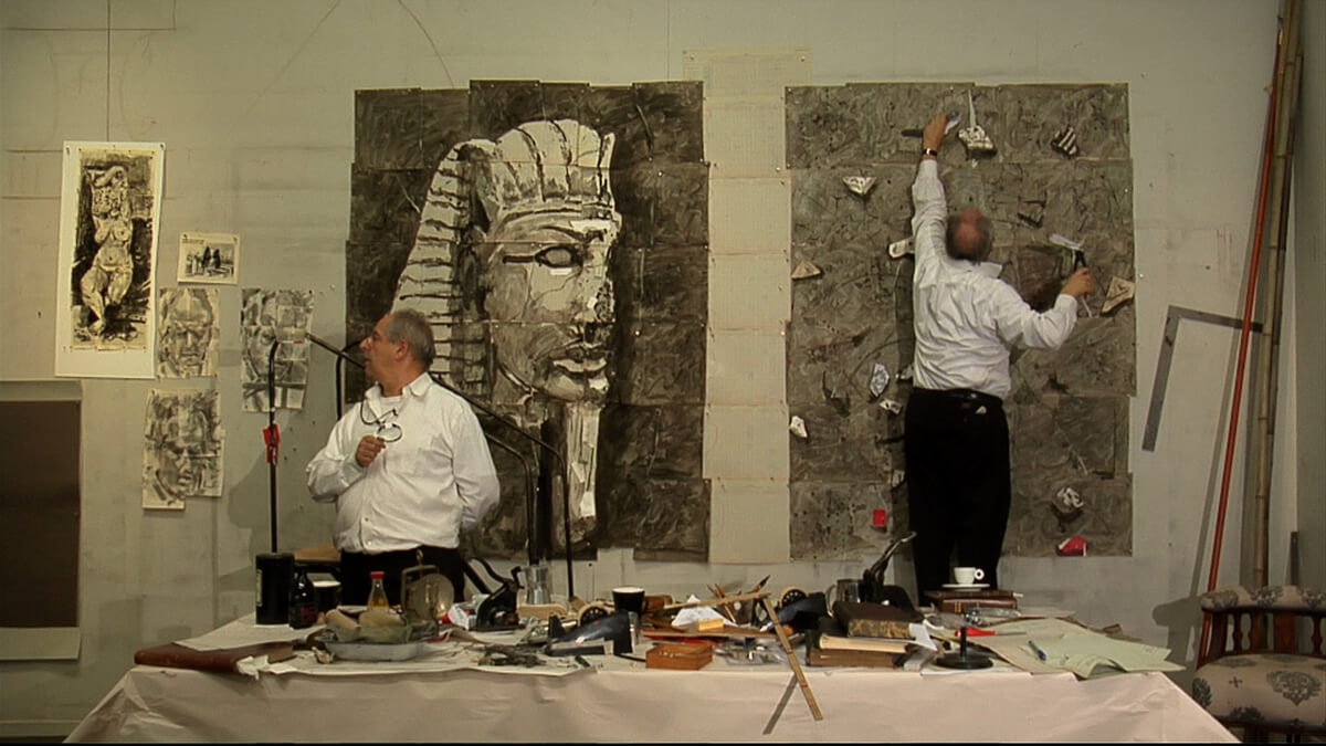Artist working on large scale egyptian style paintings