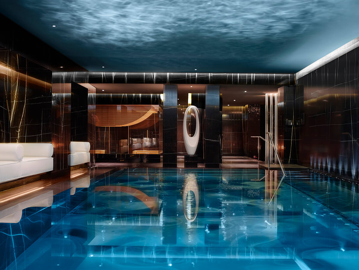 Luxury indoor swimming pool with soft lighting and blue tiles