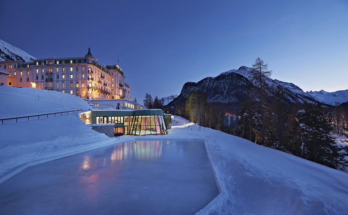 Ski resort hotel pictured at night with an indoor swimming pool and ice rink