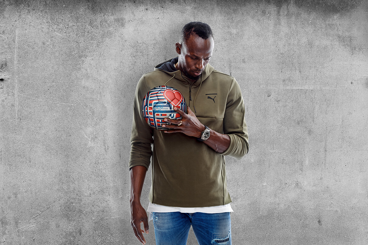 Hublot brand ambassador Usain Bolt poses in front of textured wall