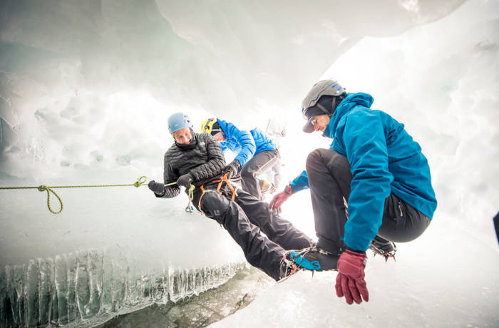 Explorers climb through an ice cave in the South Pole