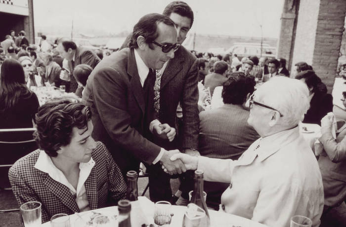 Vintage photograph of Jack Heuer of TAG Heuer swiss watches greeting Enzo Ferrari seated at a table