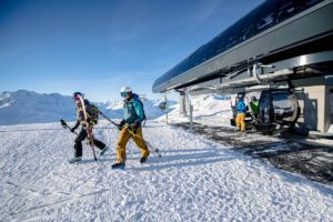 Skiers walking away from a ski lift