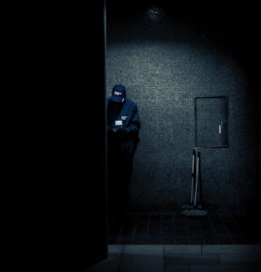 After dark photo by Italian photographer Edo Zollo of man hiding in an alley