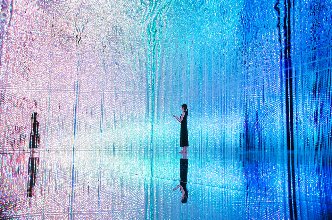 Immersive digital art installation with coloured lights surrounding a room