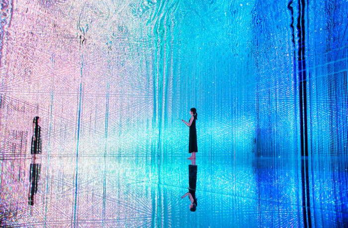 Immersive digital art installation with coloured lights surrounding a room