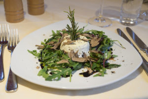Food image of a goats cheese salad with rocket and truffle shavings