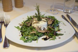 Food image of a goats cheese salad with rocket and truffle shavings