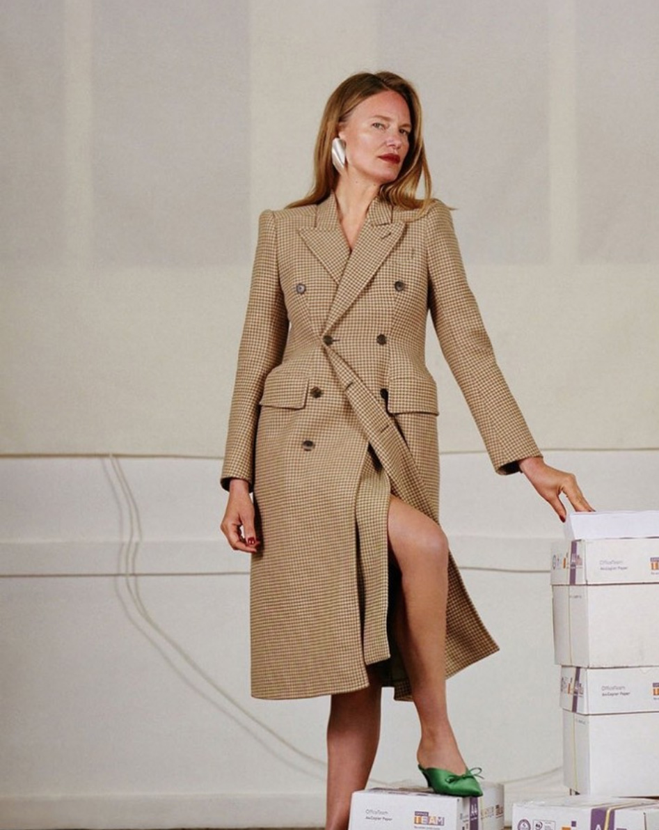 Model poses in tweed coat standing on pile of boxes