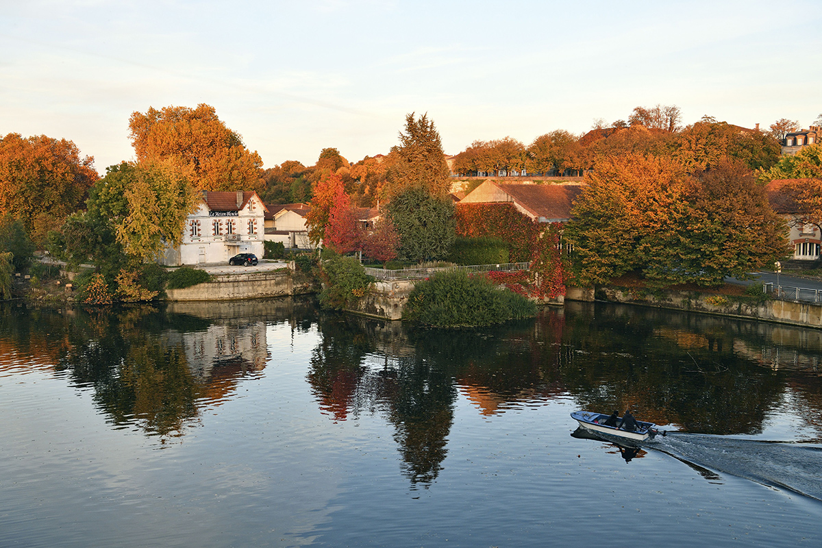 Picturesque setting of a house on the edge of a river in Autumn