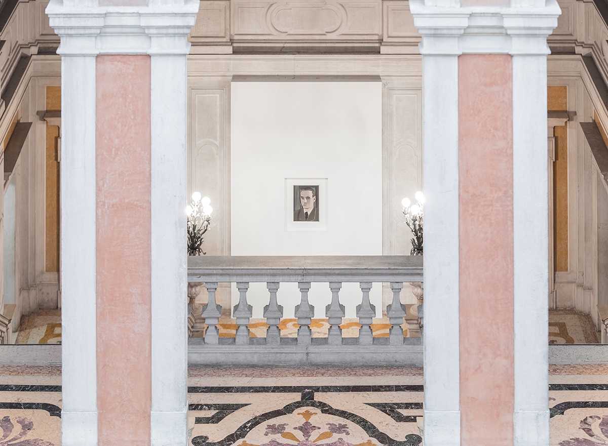 Installation shot of a Luc Tuymans exhibition with a small painting between two columns at the top of stairs