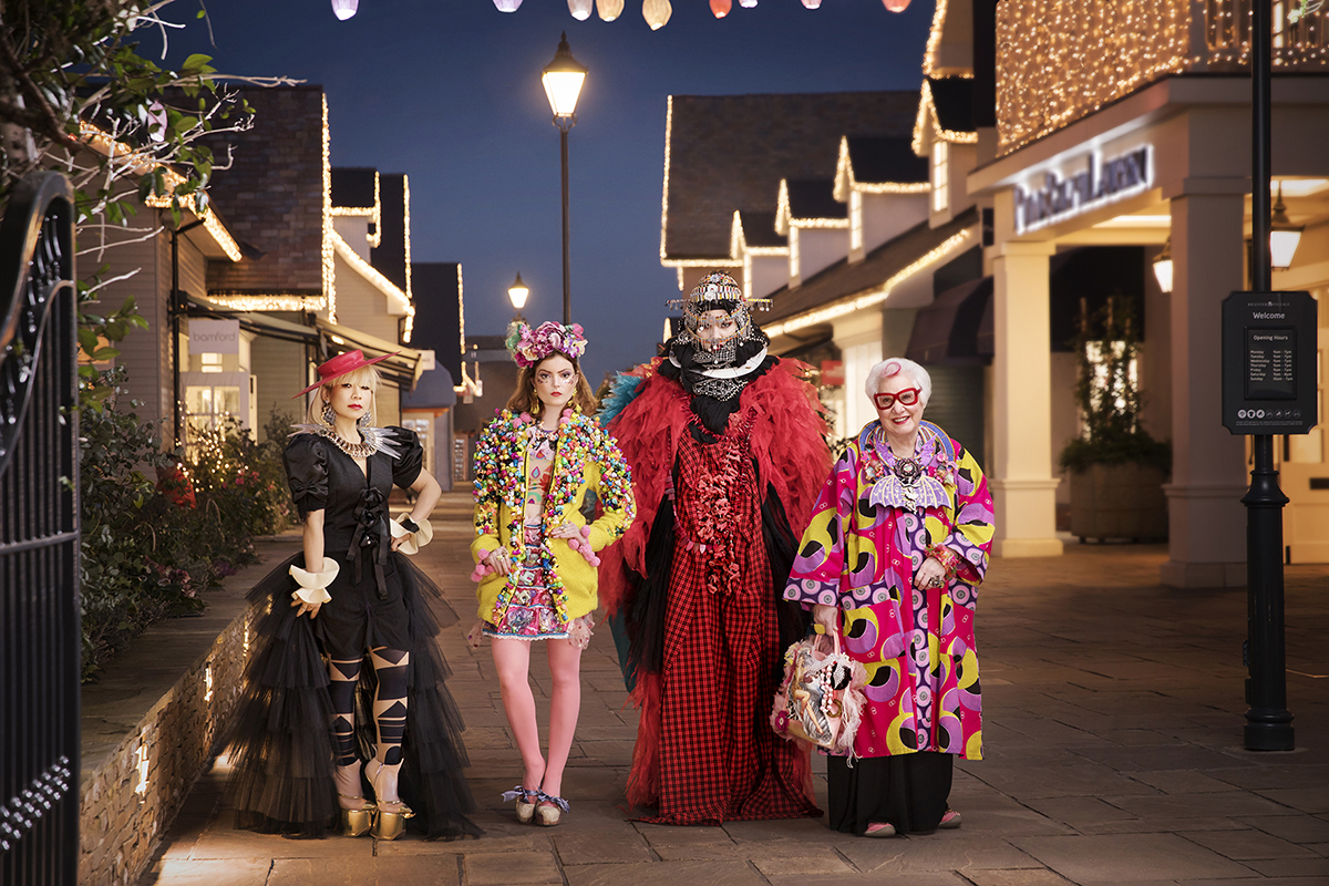 Eccentrically dressed artists pose in Bicester Village luxury retail destination