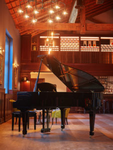 A grand piano in a rustic wooden setting