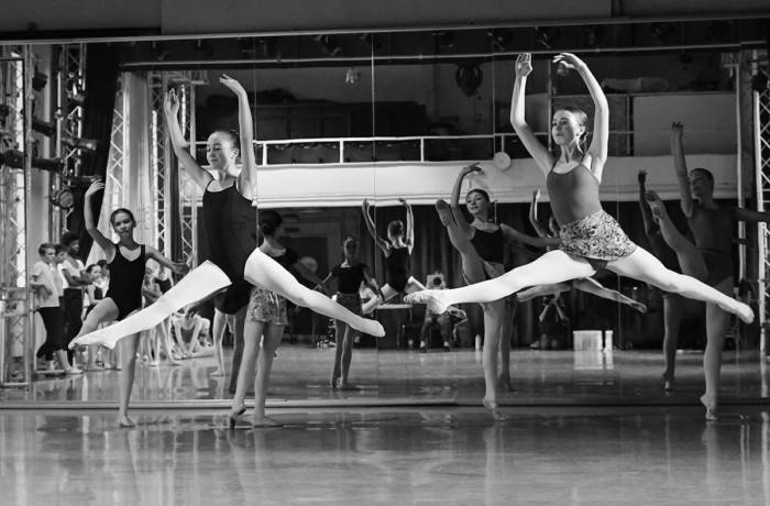 Two young ballet dancers leaping in unison