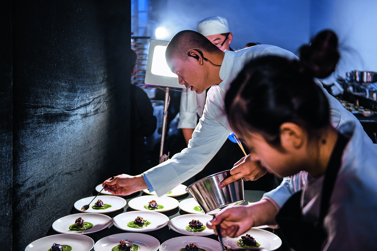 A chef and assistant plating up dinner in the kitchen