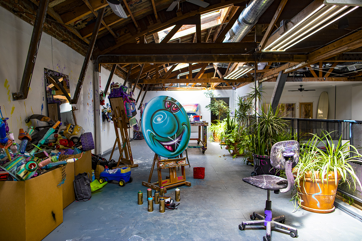 Artist studio belonging to Kenny Scharf with one of his pop art paintings on a round canvas
