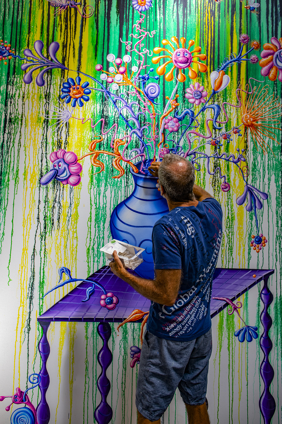 Artist Kenny Scharf painting an abstract composition of flowers