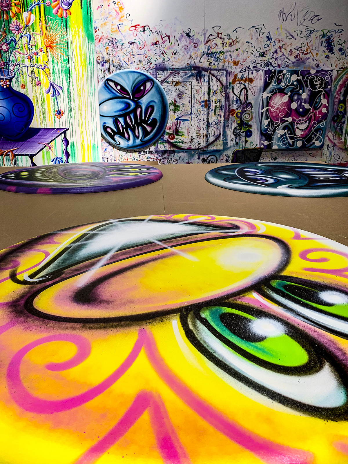 Kenny Scharf round paintings in his studio