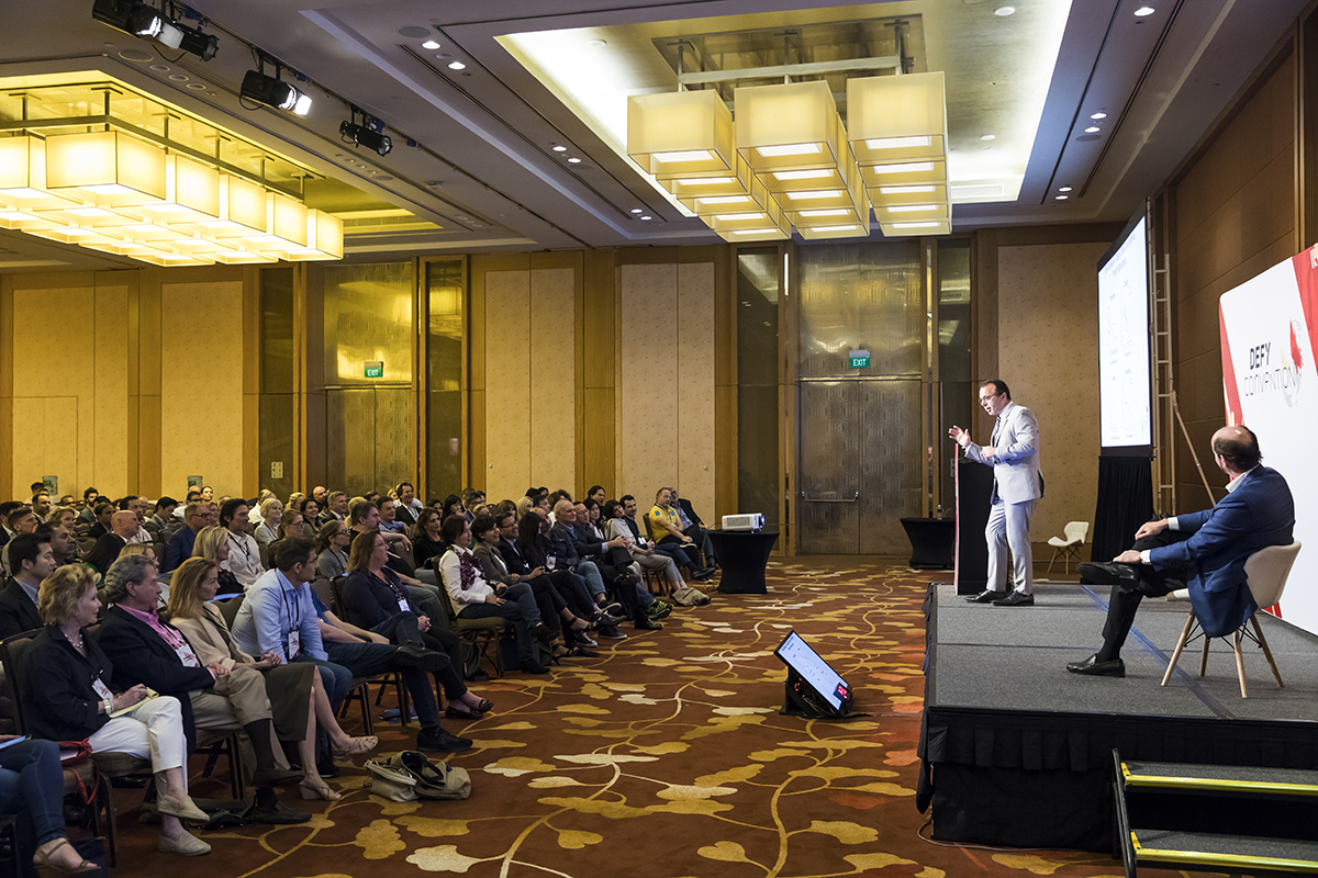 A speaker standing on stage in front of a large audience